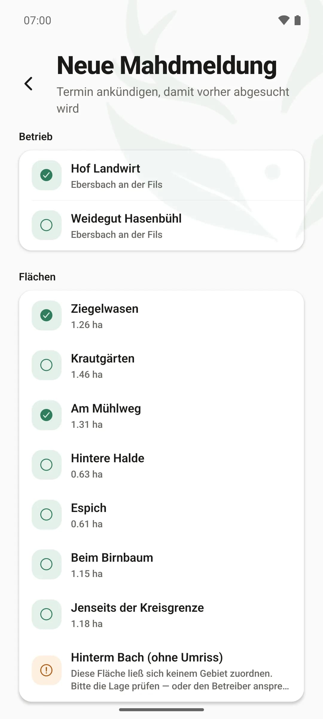 Neue Mahdmeldung in der App: Auswahl des Betriebs und darunter die eigenen Flächen mit Hektarangabe, zwei davon ausgewählt — kein Suchen nach Flurstücksnummern